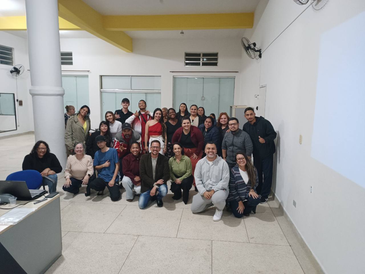 Foto da turma reunida, com sorrisos e gestos de comemoração.